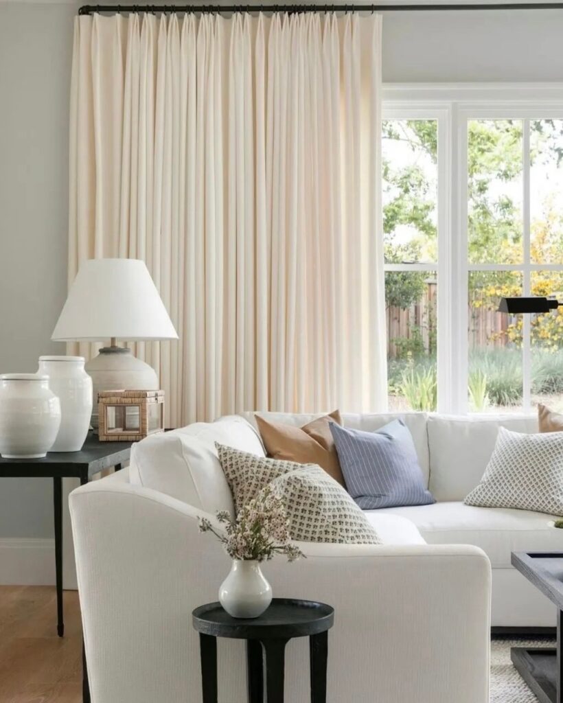 Revolution fabrics on a sofa and pillows with drapery in the background.