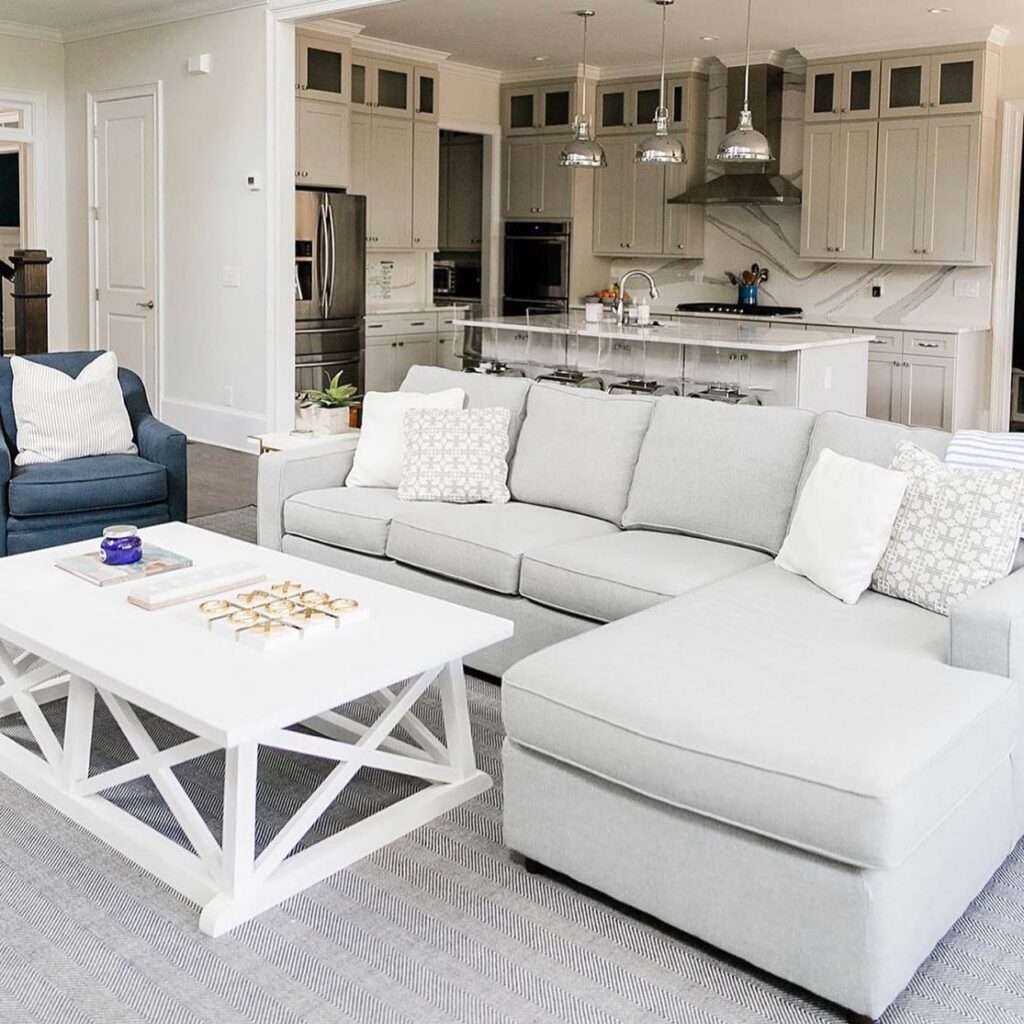 Family room farmhouse style furniture with revolution fabrics and kitchen in background.