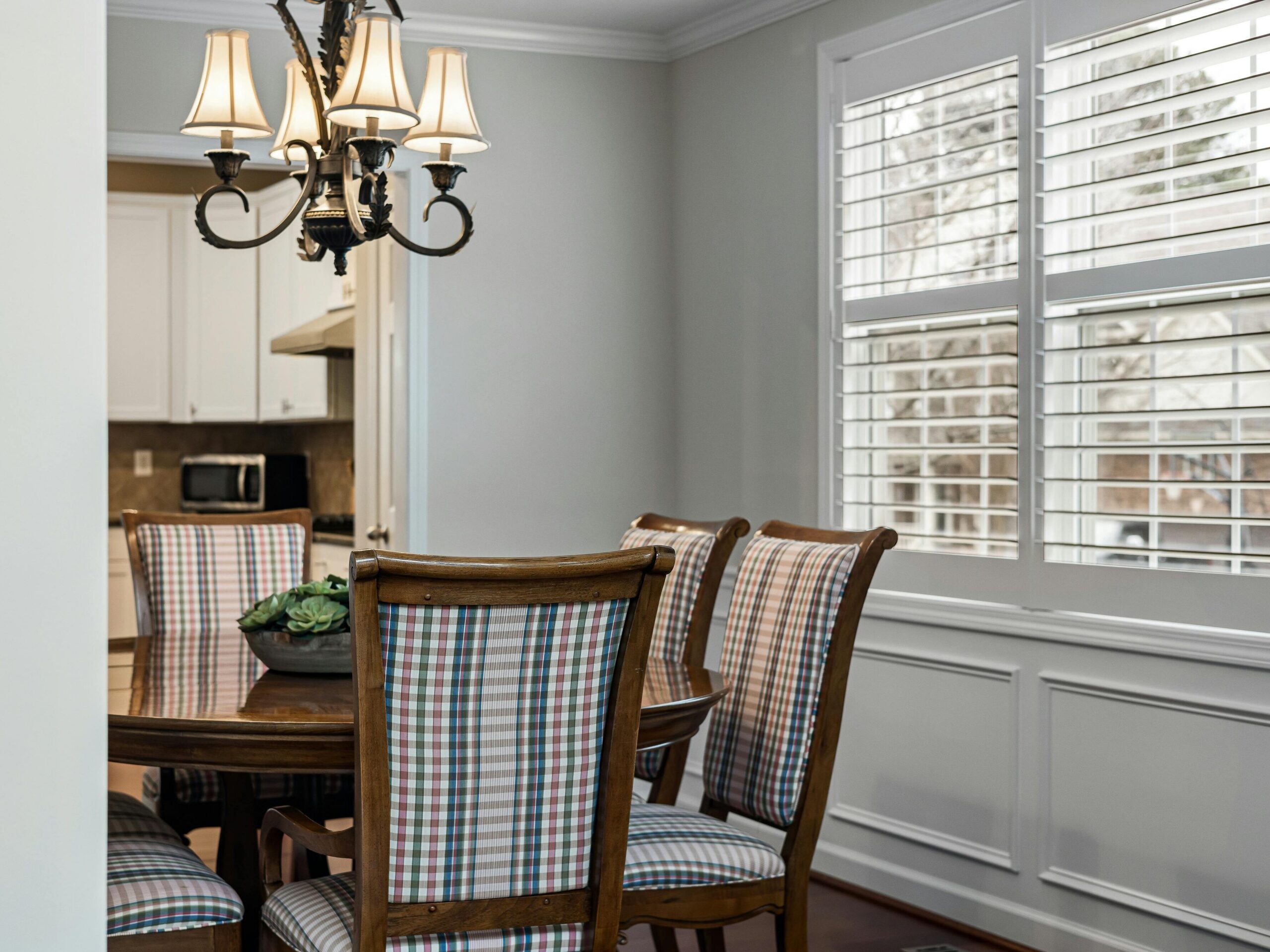 Wood shutters installed in a dining room that is traditional style in Houston.